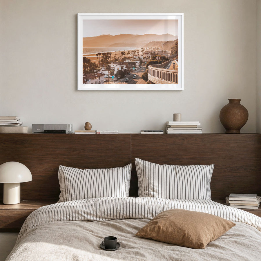 Santa Monica Photo Poster in a white wood frame, hanging in a bedroom, white border