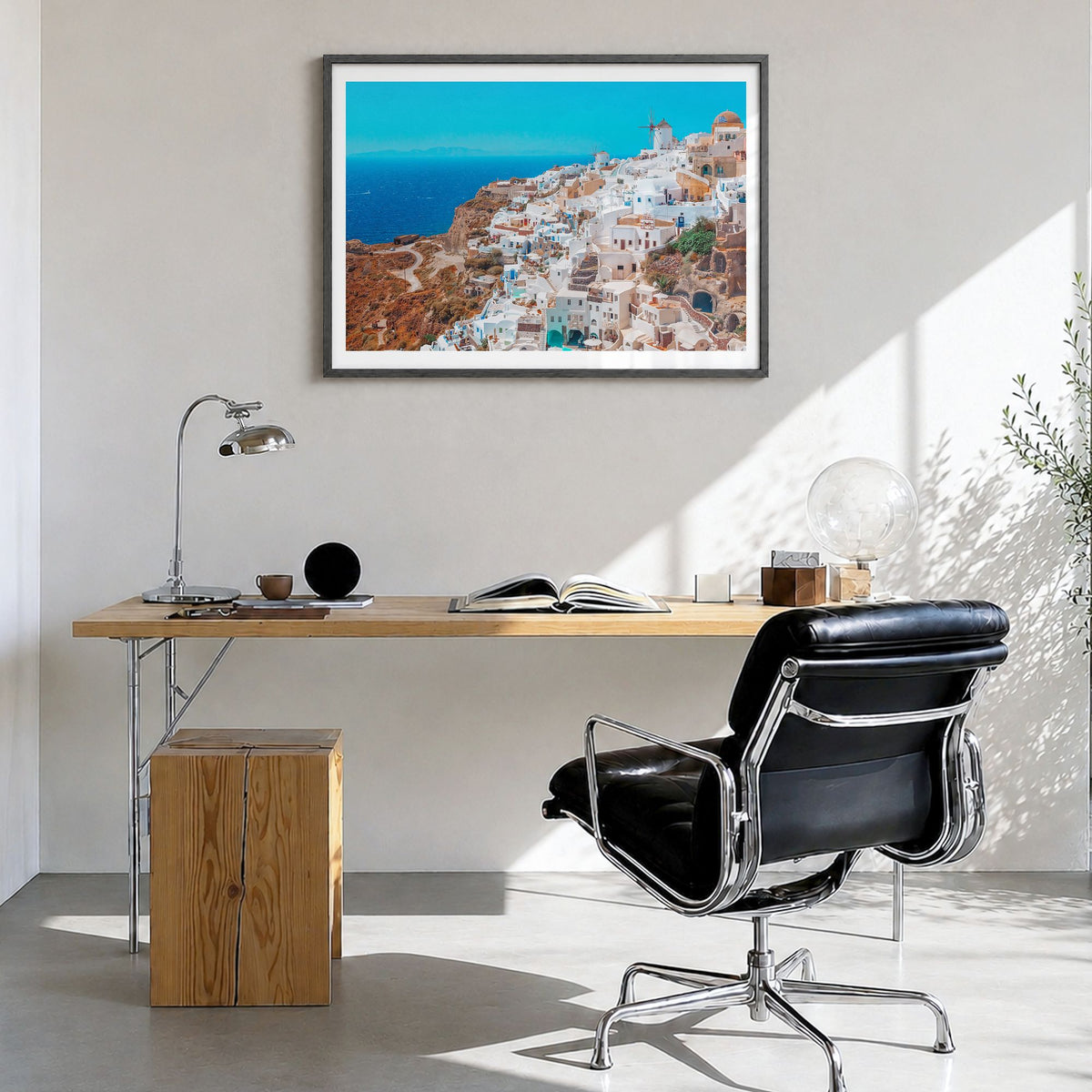 Santorini Photo Poster in a black wood frame, hanging in a bright home office, white border