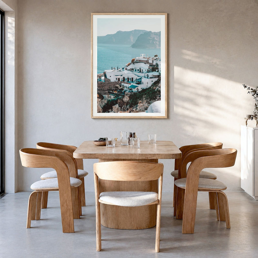 Santorini Photo No 3 Poster in a natural wood frame, hanging in a dining room, white border