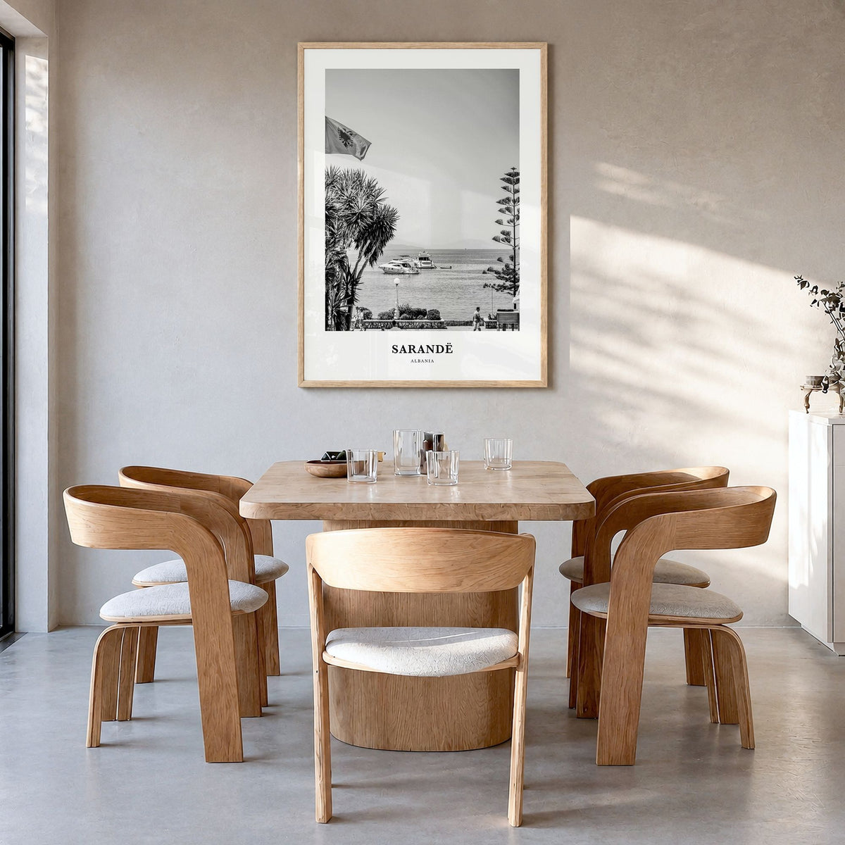 Sarandë Classic Poster in a natural wood frame, hanging in a dining room