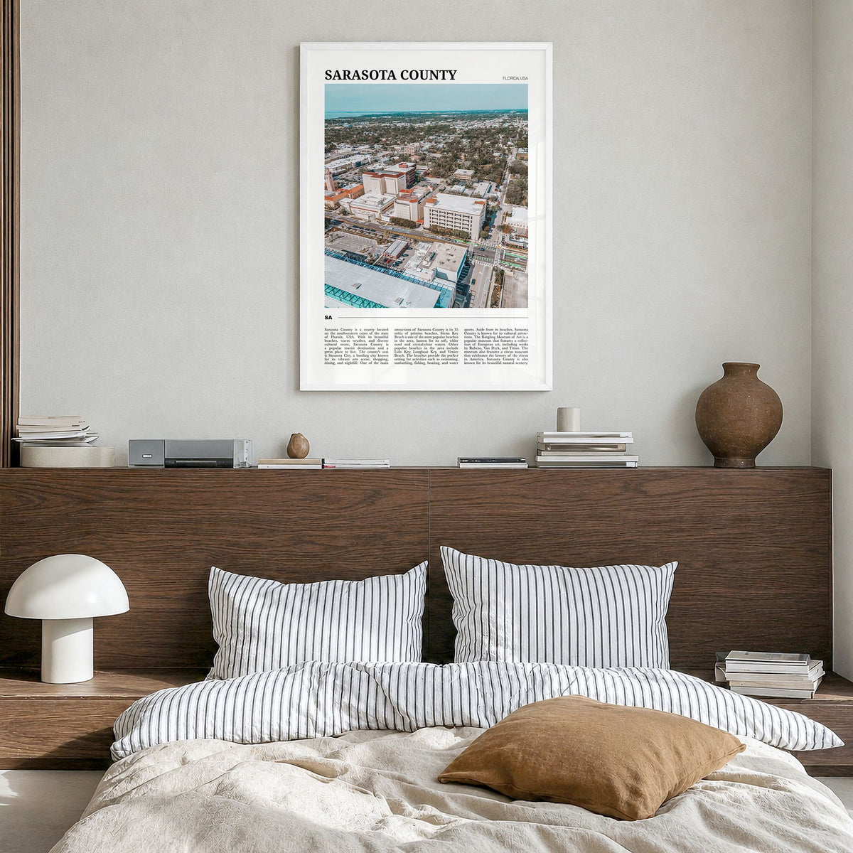 Sarasota County Travel Poster in a white wood frame, hanging in a bedroom
