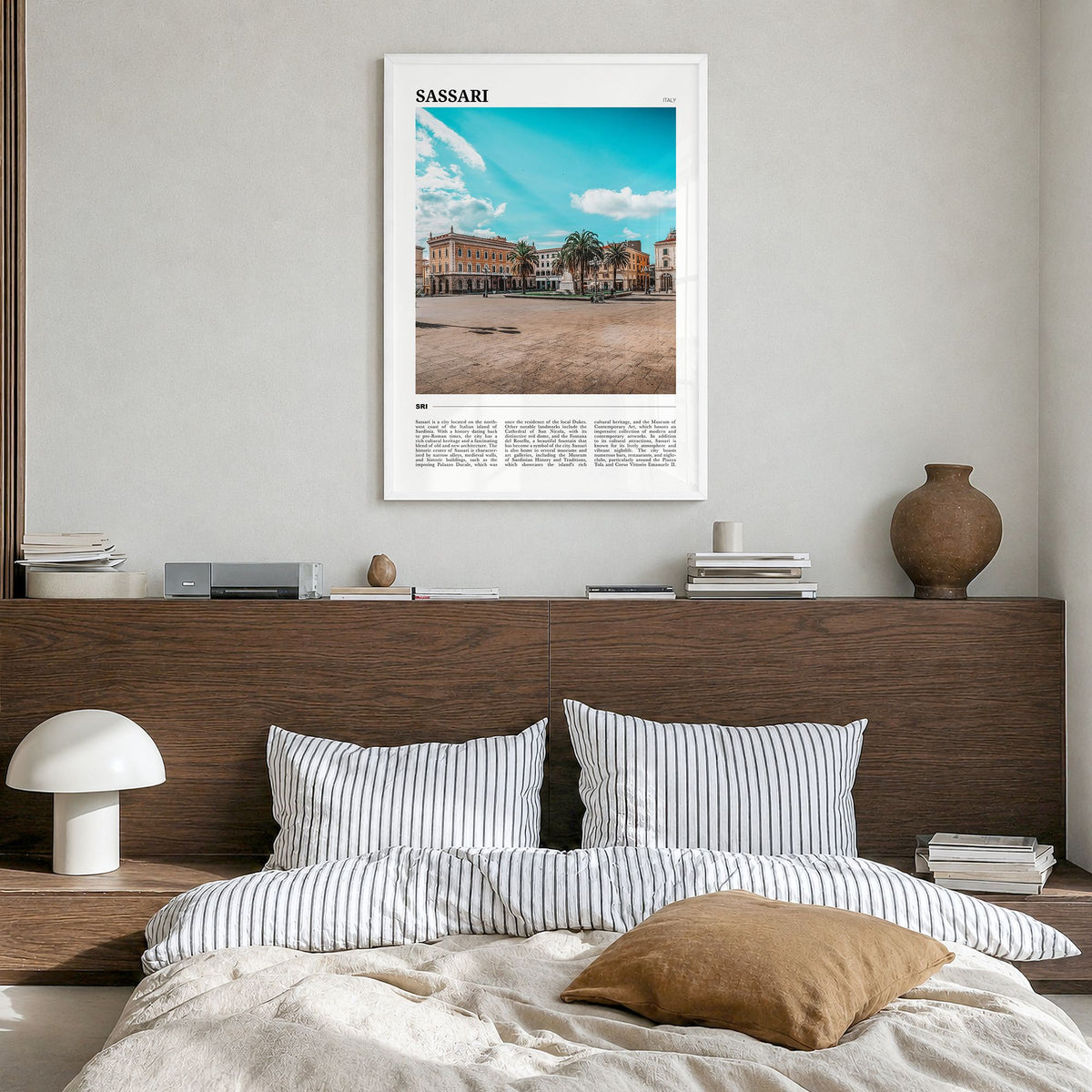 Sassari Travel Poster in a white wood frame, hanging in a bedroom