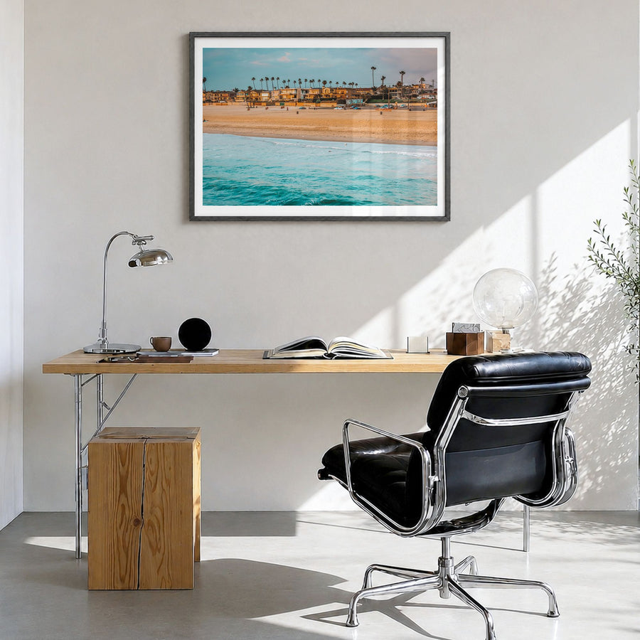 Seal Beach Photo Poster in a black wood frame, hanging in a bright home office, white border