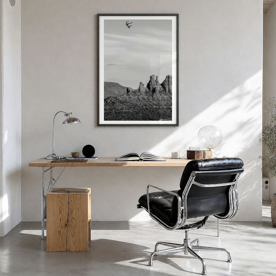 Sedona Photo Poster in a black wood frame, hanging in a bright home office, white border