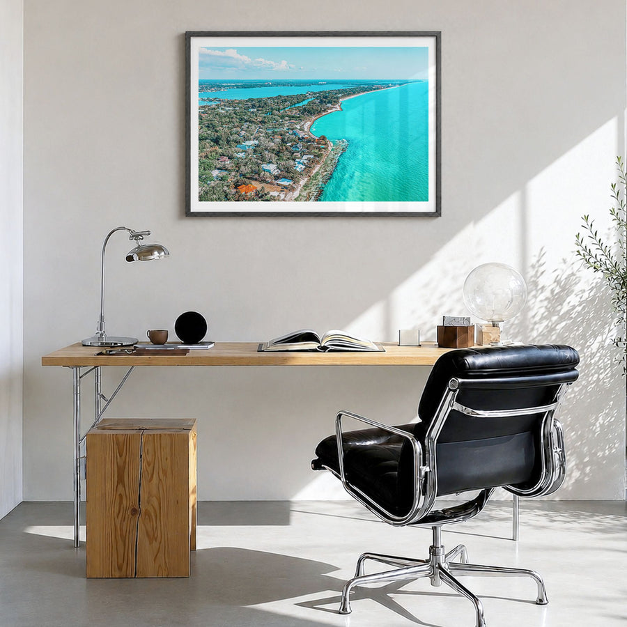 Siesta Key Photo Poster in a black wood frame, hanging in a bright home office, white border