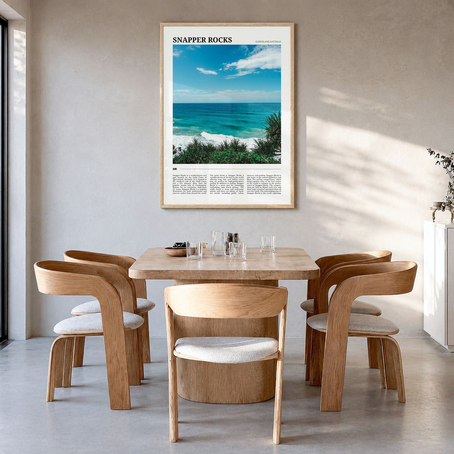 Snapper Rocks Travel Poster in a natural wood frame, hanging in a dining room