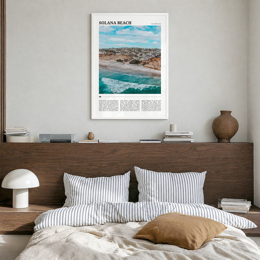 Solana Beach Travel Poster in a white wood frame, hanging in a bedroom
