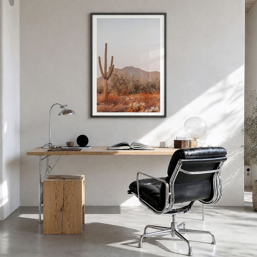 Sonora Photo Poster in a black wood frame, hanging in a bright home office, white border