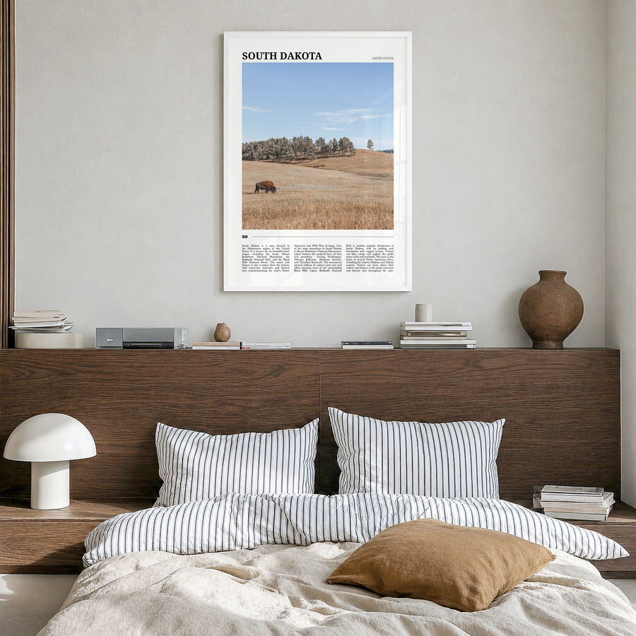 South Dakota Travel Poster in a white wood frame, hanging in a bedroom