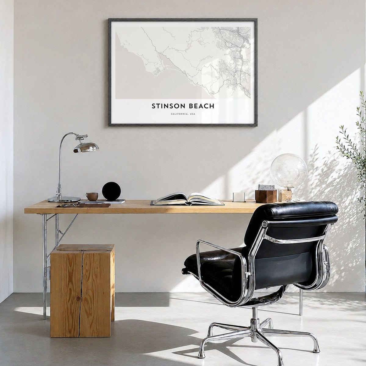 Stinson Beach Map Poster in a black wood frame, hanging in a bright home office