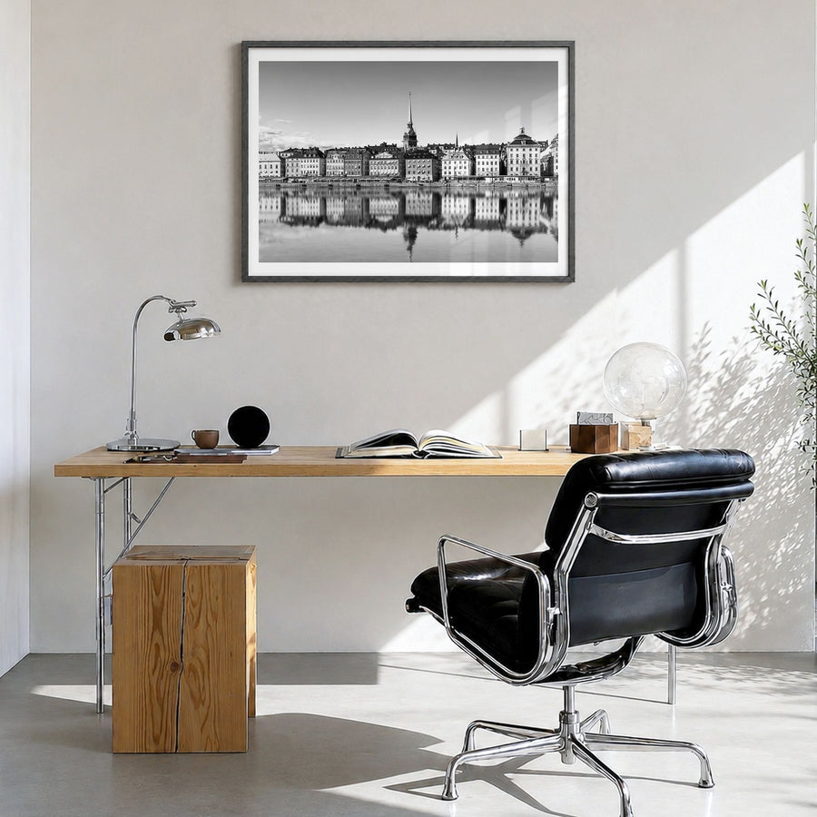Stockholm Photo Poster in a black wood frame, hanging in a bright home office, white border