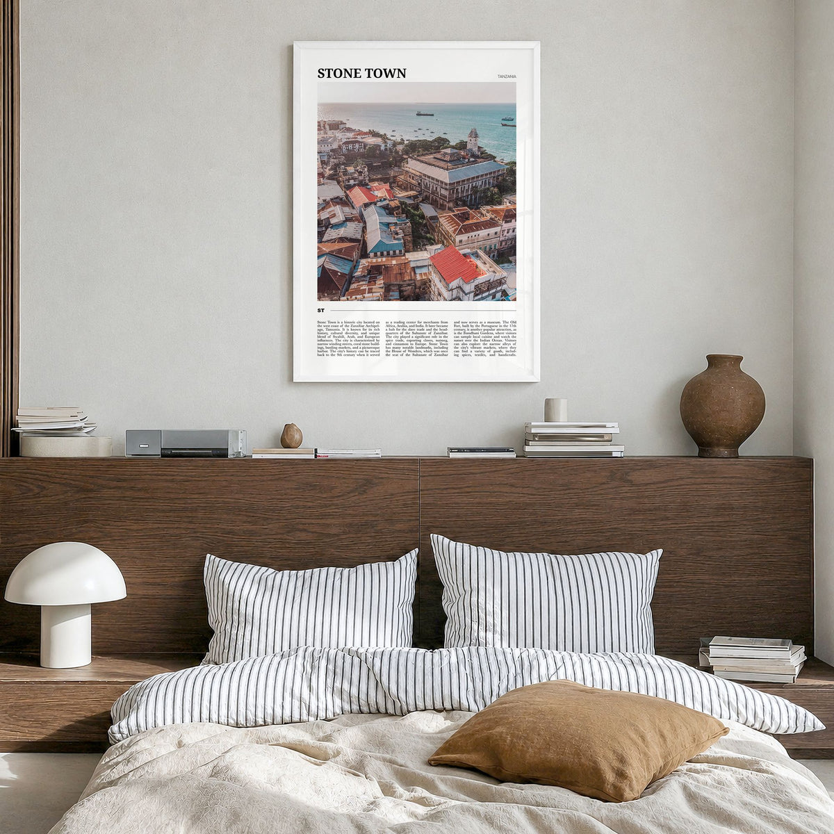 Stone Town Travel Poster in a white wood frame, hanging in a bedroom