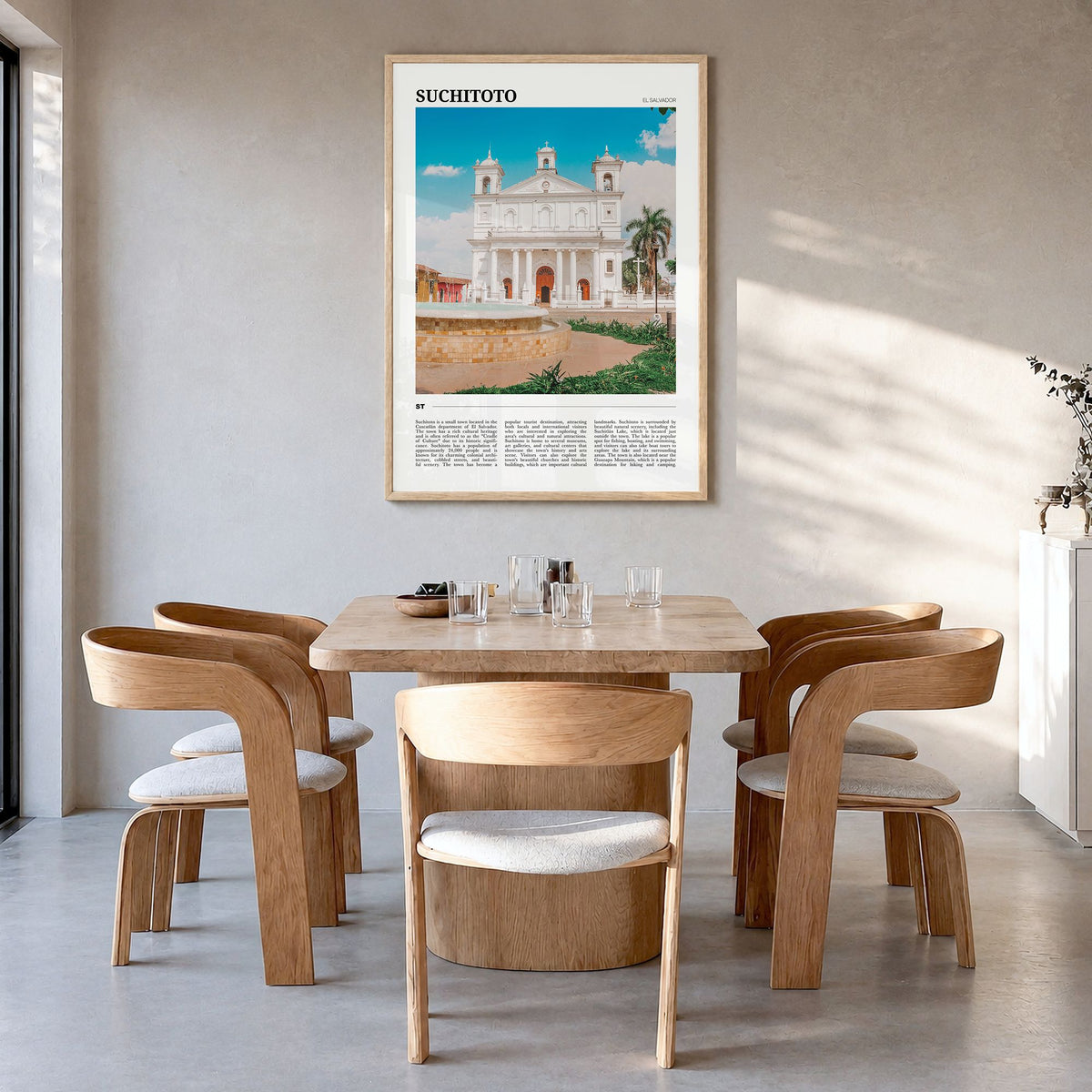 Suchitoto Travel Poster in a natural wood frame, hanging in a dining room
