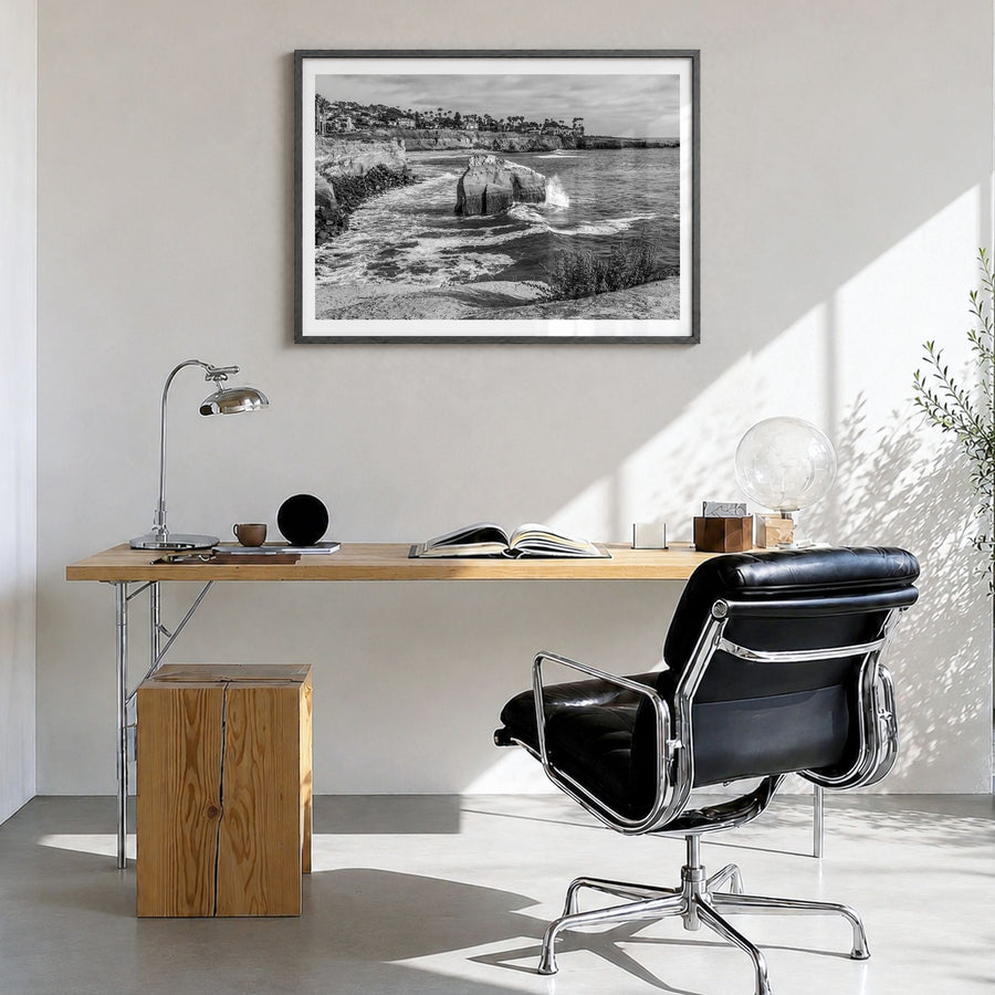 Sunset Cliffs Photo Poster in a black wood frame, hanging in a bright home office, white border