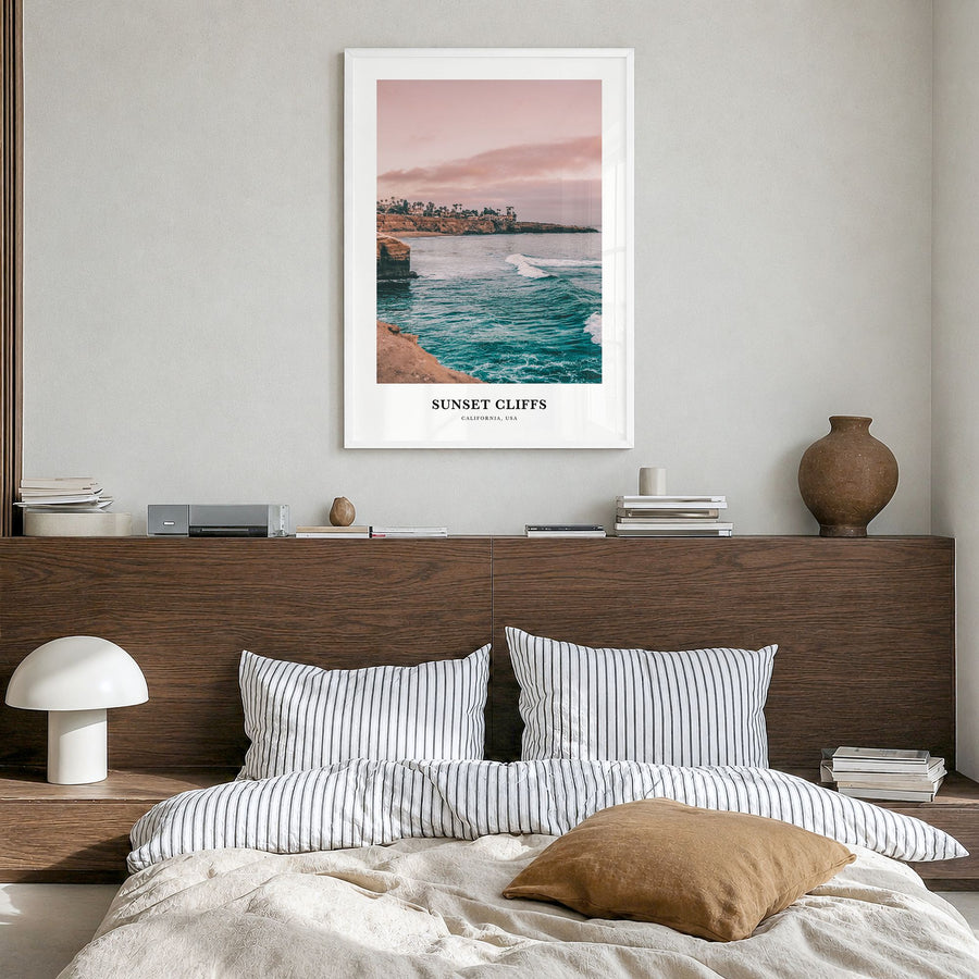 Sunset Cliffs Classic Poster in a white wood frame, hanging in a bedroom