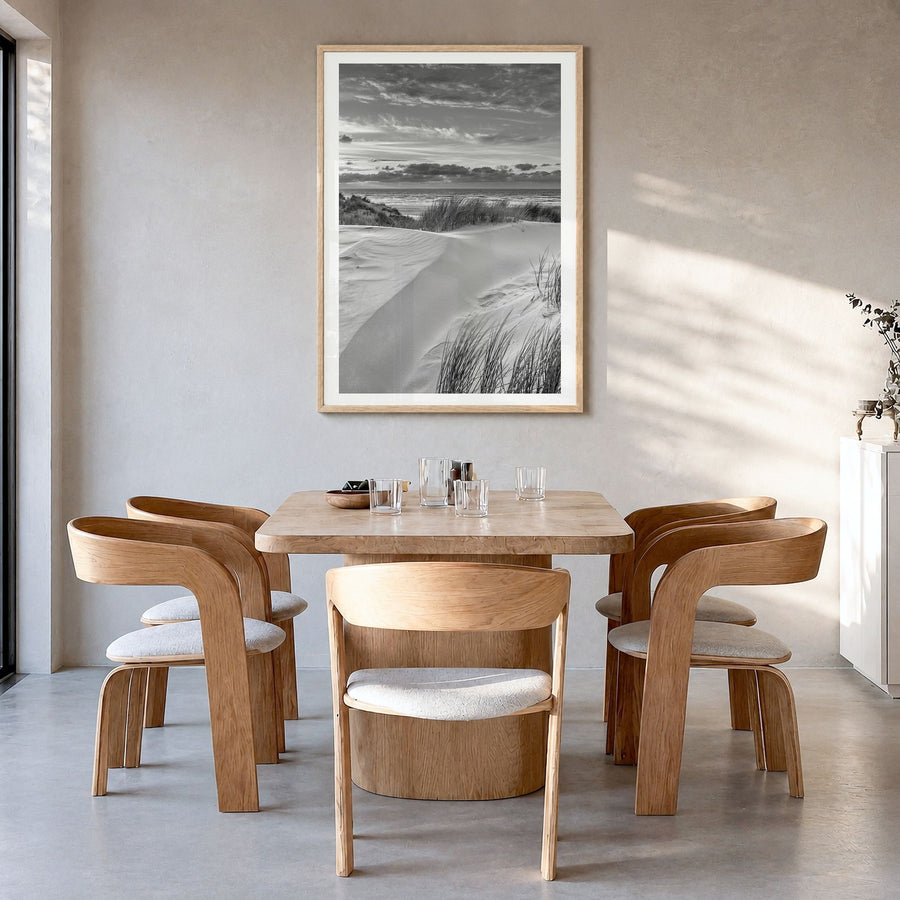 Sunset Coast Photo Poster in a natural wood frame, hanging in a dining room, white border