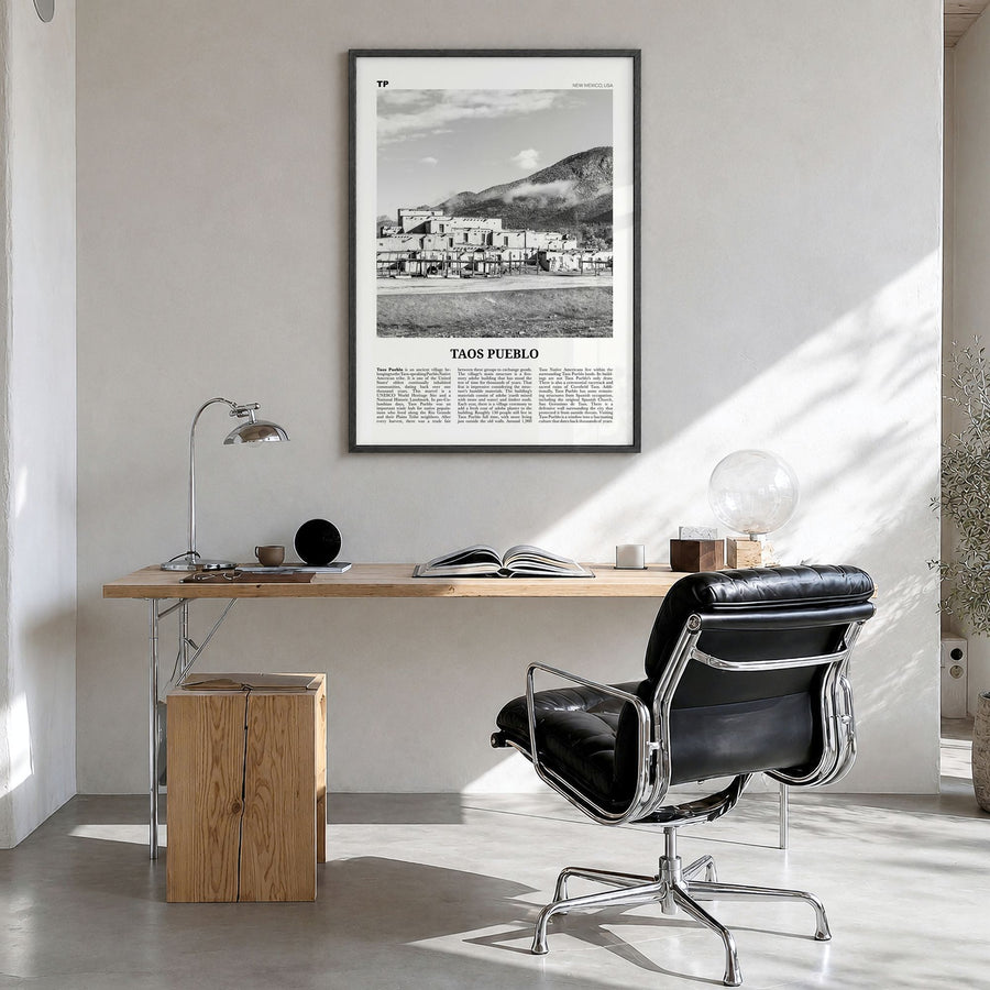 Taos Pueblo Newspaper Poster in a black wood frame, hanging in a bright home office