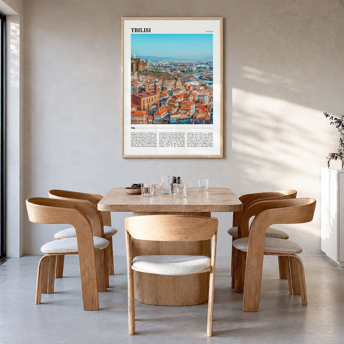 Tbilisi Travel Poster in a natural wood frame, hanging in a dining room