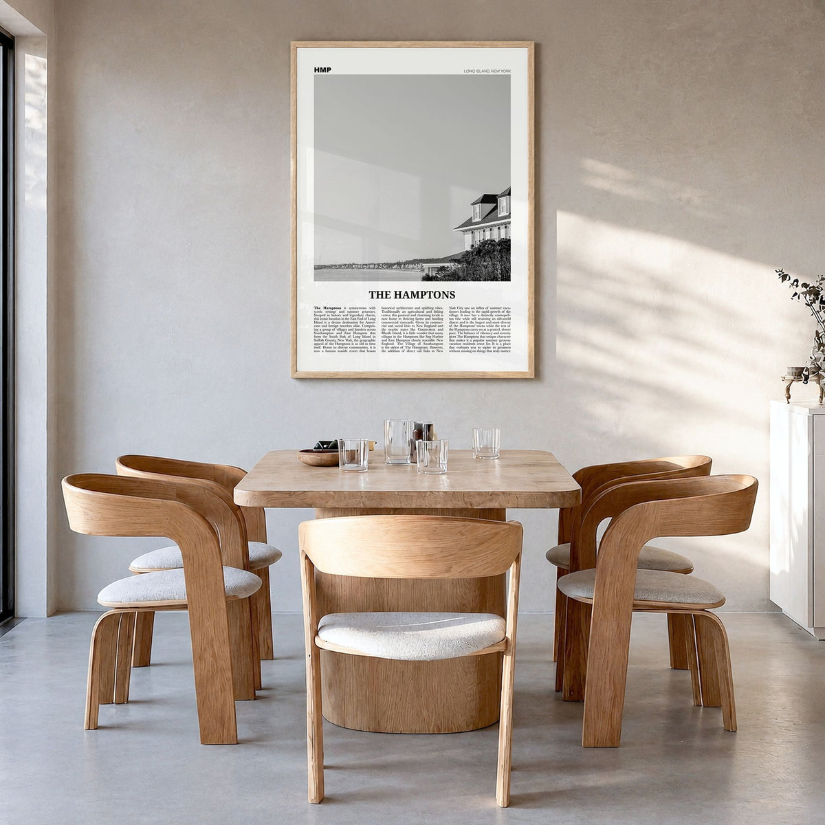 The Hamptons Newspaper Poster in a natural wood frame, hanging in a dining room