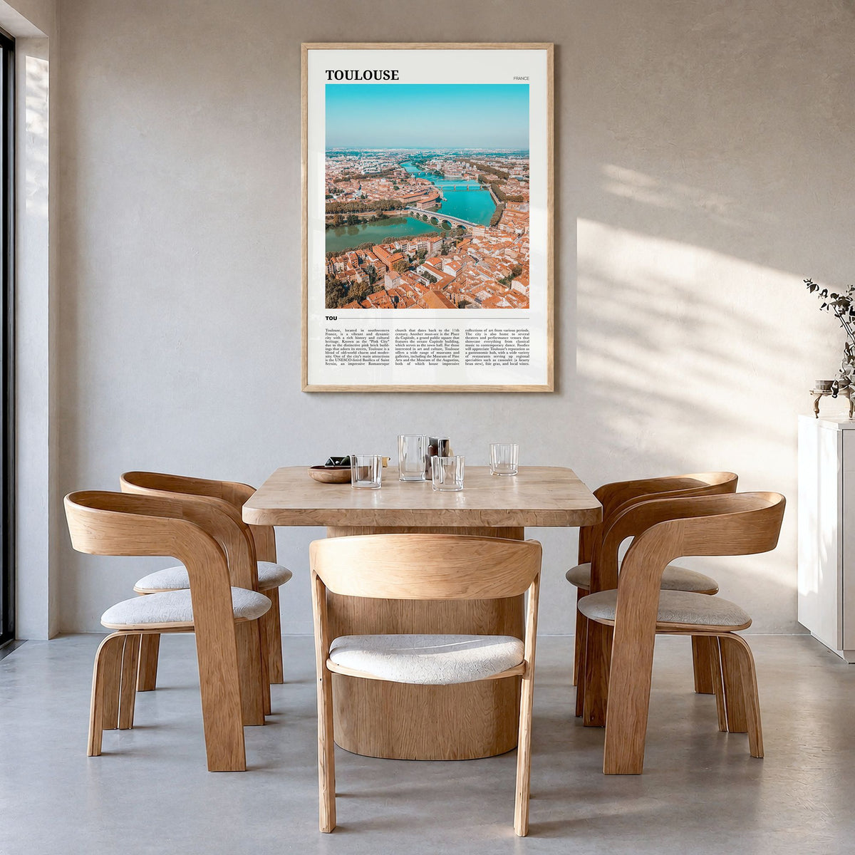 Toulouse Travel Poster in a natural wood frame, hanging in a dining room