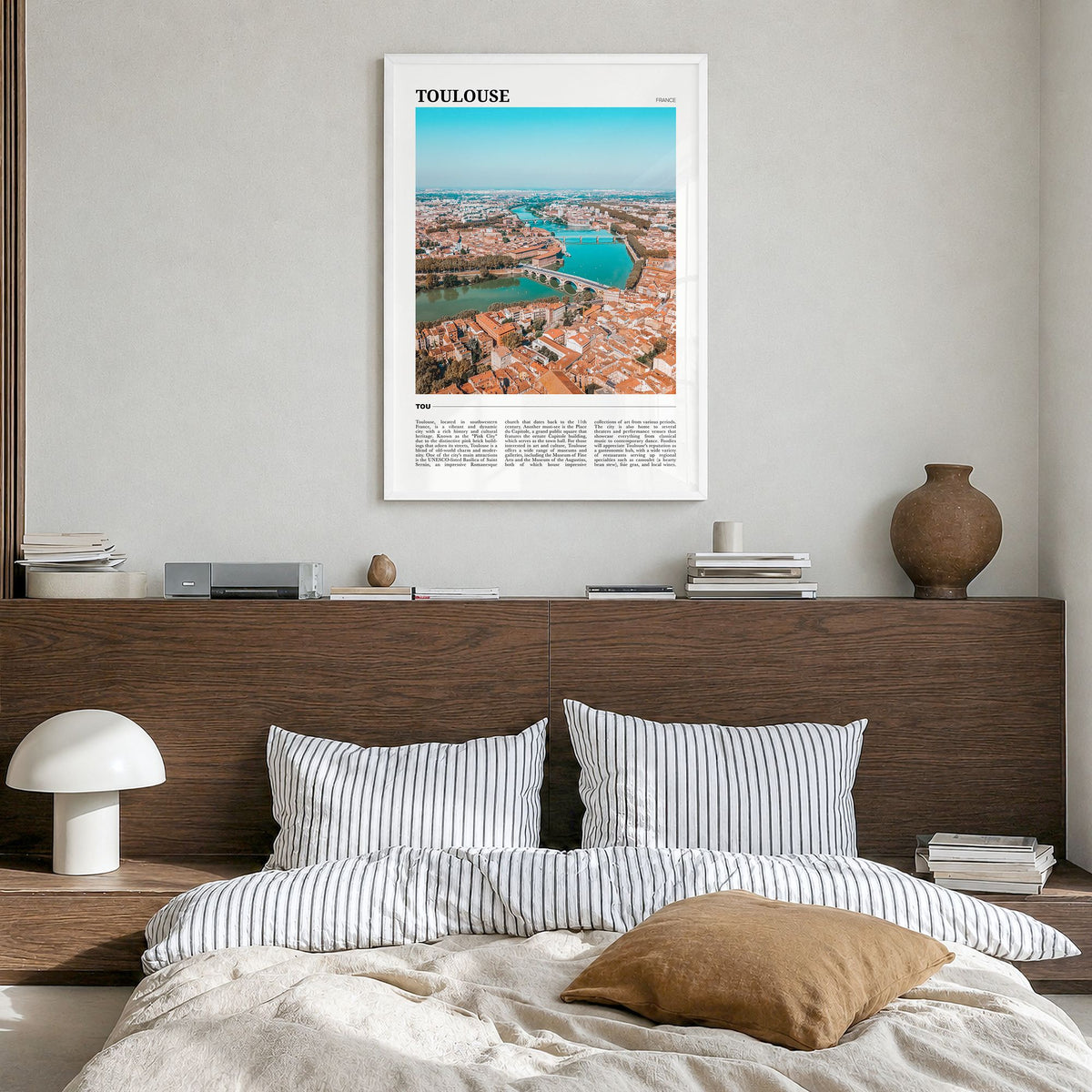 Toulouse Travel Poster in a white wood frame, hanging in a bedroom