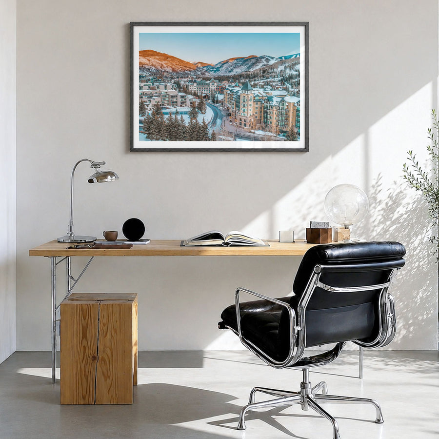 Vail Photo Poster in a black wood frame, hanging in a bright home office, white border