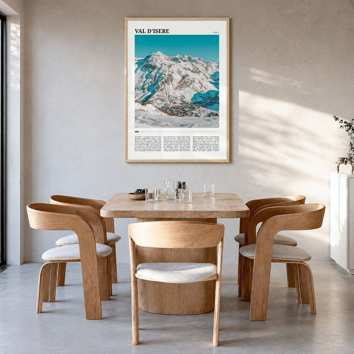 Val d'Isère Travel Poster in a natural wood frame, hanging in a dining room