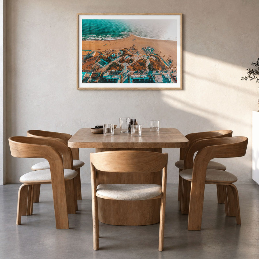Venice Beach Photo Poster in a natural wood frame, hanging in a dining room, white border
