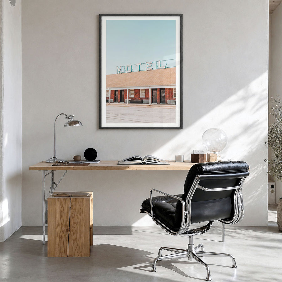 Vintage Motel Photo Poster in a black wood frame, hanging in a bright home office, white border