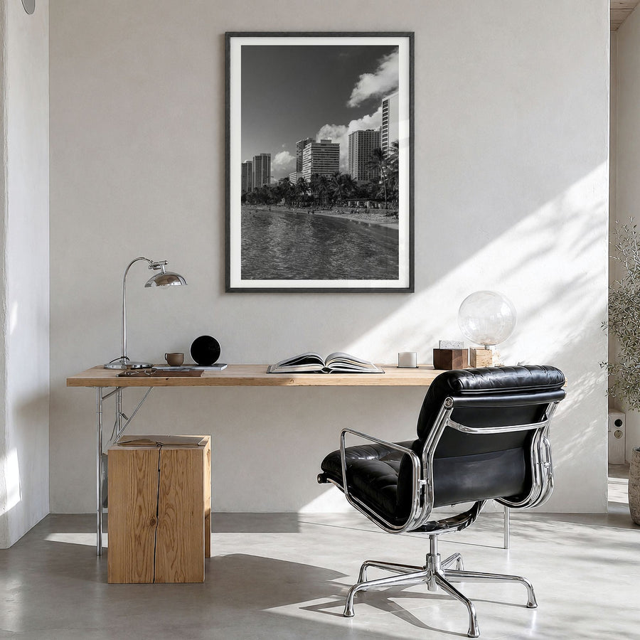 Waikiki Photo Poster in a black wood frame, hanging in a bright home office, white border