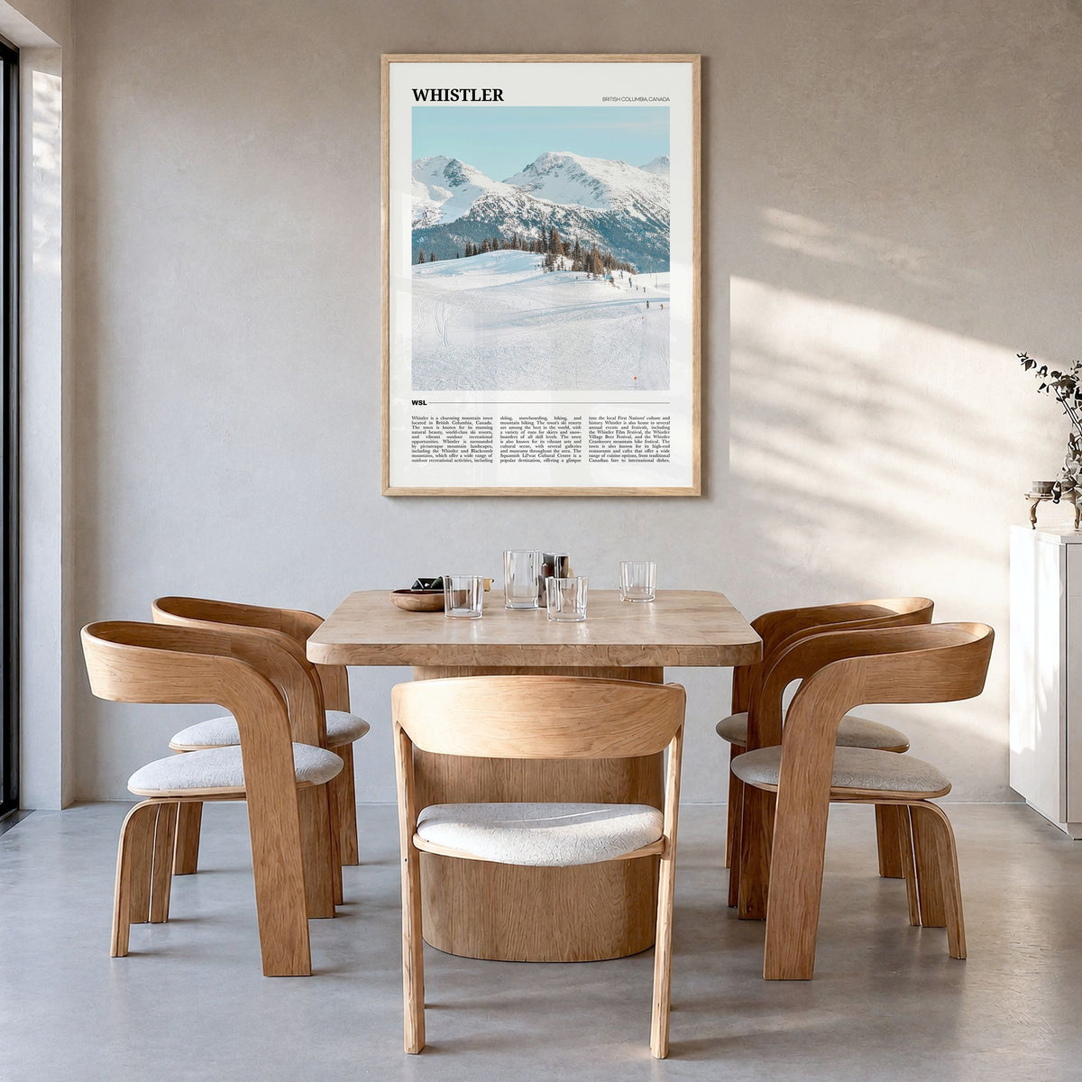 Whistler Travel Poster in a natural wood frame, hanging in a dining room
