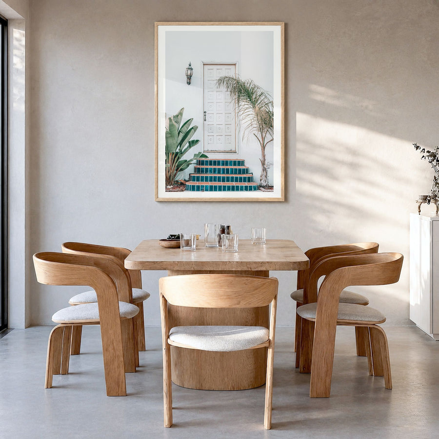 White Door Photo Poster in a natural wood frame, hanging in a dining room, white border