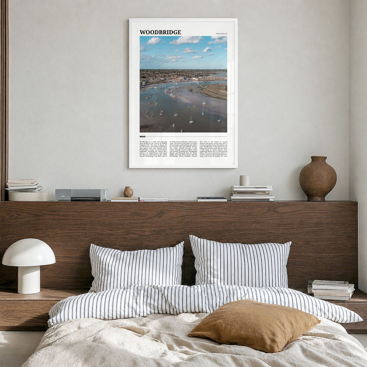Woodbridge Travel Poster in a white wood frame, hanging in a bedroom
